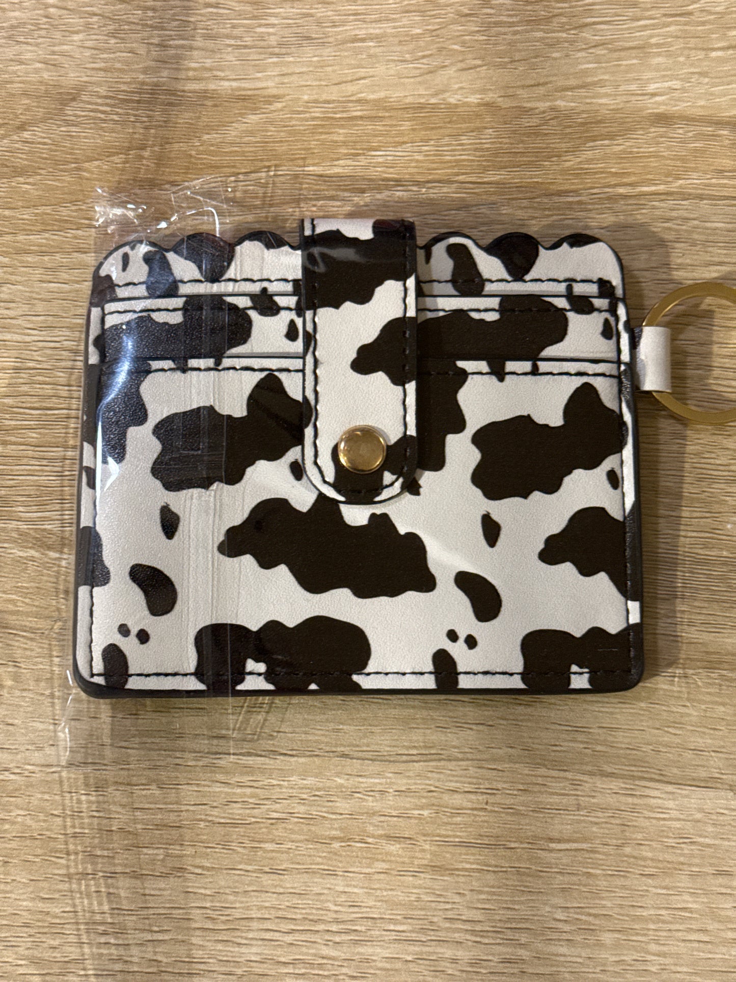 Cartera grande con estampado de vaca y herrajes dorados